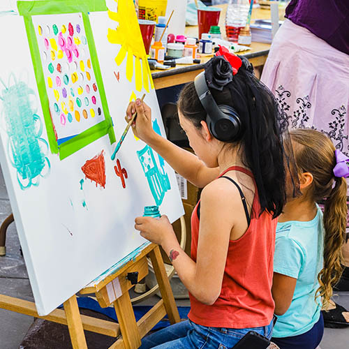 Two children painting on a canvas